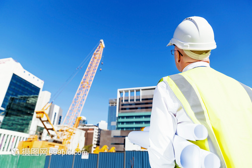 建筑工地的工程師建設(shè)者工程師建筑工人施工場景穿著帶藍圖的安全背心